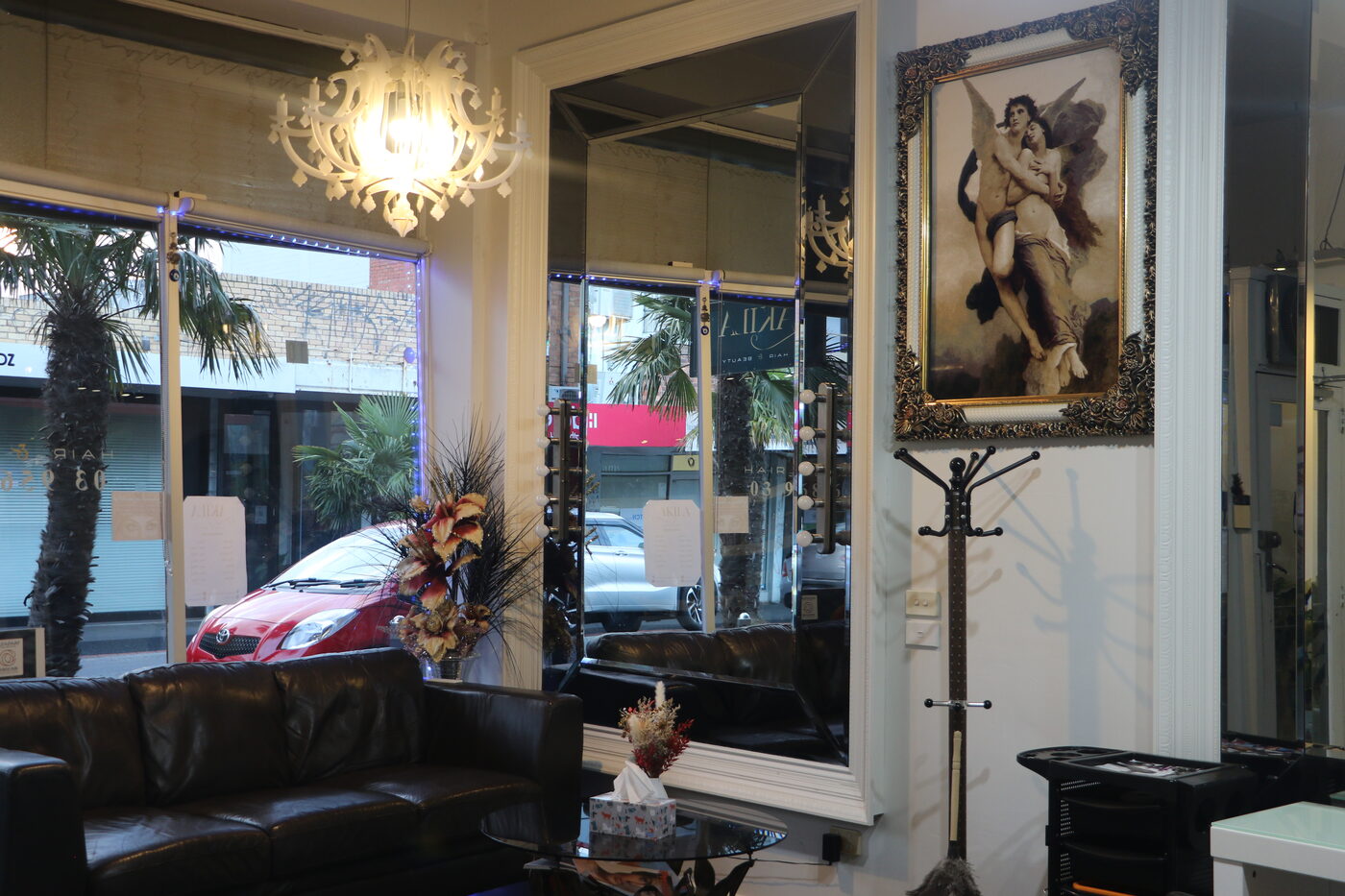 Inside Akila Hair Salon, Oakleigh, with chandelier, mirrors, Persian art, and the lounge by the window