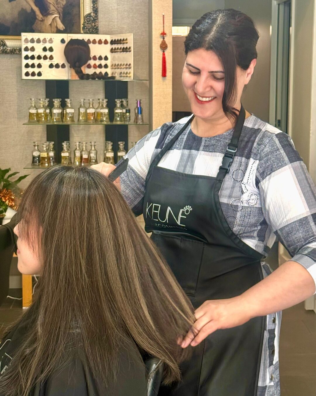 Zara checking a client's hair at Akila Hair and Beauty in Oakleigh